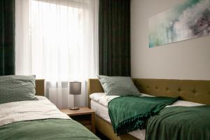 a bedroom with two beds and a window at Apartament Leśny No 5 Green ,garaż w cenie in Kielce +25 photos