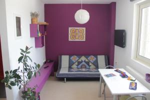 a purple room with a chair and a table at Entire independent maisonette near Heraklion Pottery Classes in Petrokefalo