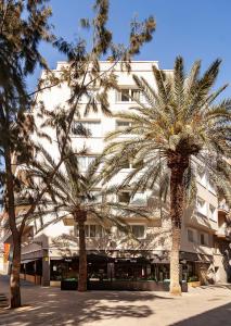 a large building with palm trees and palm trees at Sixties Ramblas in Barcelona