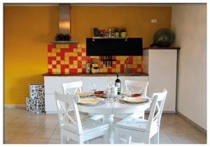 - une table et des chaises blanches dans la cuisine dans l'établissement Casa Valtaro, à Borgo Val di Taro