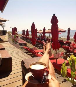 een persoon op het strand met een kopje koffie bij Modern 2 bedroom Beach Apartment in Limassol