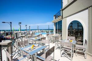 a patio with tables and chairs on a balcony at Hotel Sayonara in Cattolica