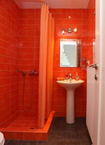 baño rojo con ducha y lavamanos en Entire independent maisonette near Heraklion Pottery Classes en Petrokefalo