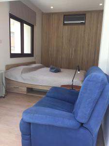 ein Schlafzimmer mit einem Bett und einem blauen Stuhl in der Unterkunft Modern 2 bedroom Beach Apartment in Limassol