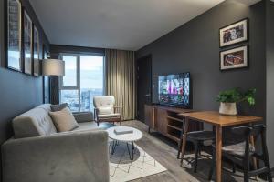 a living room with a couch and a tv at The Gate London City in London