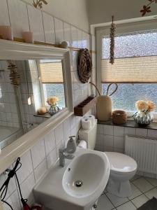 een badkamer met een witte wastafel en een toilet bij Ferienhaus am Scharnhorst in Hameln