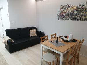 uma sala de estar com um sofá preto e uma mesa em São João Oporto Residence I & II no Porto