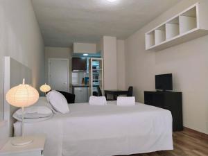 1 dormitorio con 1 cama blanca grande con almohadas blancas en Apartamentos Centro Norte, en Madrid