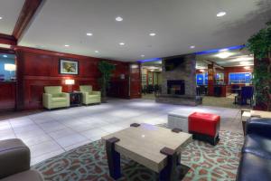 a lobby with a table and chairs and a fireplace at Holiday Inn Express and Suites Dawson Creek, an IHG Hotel in Dawson Creek