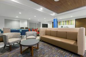 a lobby with a couch and chairs and a table at Holiday Inn Express Hotel & Suites Eugene Downtown - University, an IHG Hotel in Eugene