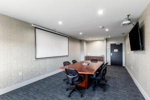 a conference room with a table and chairs and a screen at Holiday Inn Express & Suites Jersey City North - Hoboken by IHG in Jersey City