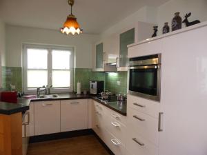 una cocina con armarios blancos y fregadero en Alpenflair Ferienwohnungen Whg 301 en Oberstdorf