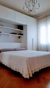 een slaapkamer met een groot wit bed met een kroonluchter bij Letizia Apartment in Crotone