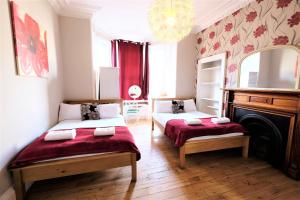 a bedroom with two beds and a fireplace and a chandelier at Balmore Guest House in Edinburgh