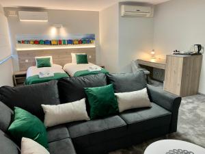 a living room with a couch and two beds at Apartamenty ELITMAT in Mińsk Mazowiecki