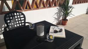 einen schwarzen Tisch und Stuhl mit einem Buch und einer Brille in der Unterkunft Apartamento Jazmín 49 Centro - Adults Recommended in Nerja