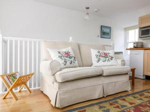 ein Wohnzimmer mit einer Couch mit Kissen darauf in der Unterkunft Rosa Cottage in Porthleven