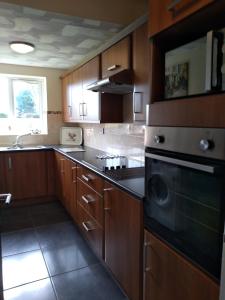 a kitchen with wooden cabinets and a stove top oven at Rosedene in Mablethorpe