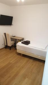 a bedroom with a bed and a table and a desk at Zimmer zur Seeve in Seevetal