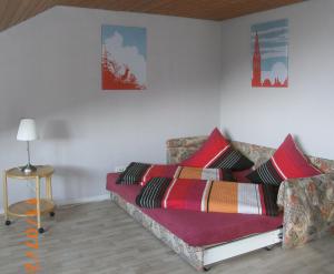 ein Sofa mit bunten Kissen darauf im Zimmer in der Unterkunft Ferienwohnung im Kupferhammer in Titisee-Neustadt