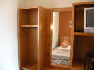 a room with a small room with a bed and a tv at Hotel Posada Real in Lagos de Moreno