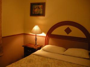 a bedroom with a bed and a lamp on a table at Hotel Posada Real in Lagos de Moreno