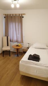 a bedroom with a bed and a table and a chair at Zimmer zur Seeve in Seevetal