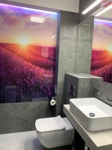 La salle de bains est pourvue de toilettes blanches et d'un lavabo. dans l'établissement Apartamenty ELITMAT, à Mińsk Mazowiecki