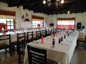 a large room with long tables with bottles of wine at Hostería El Tisaleño in Ambato