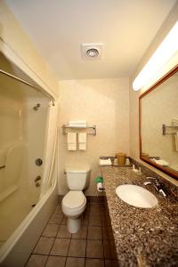 a bathroom with a toilet and a sink and a mirror at Baymont by Wyndham North Dartmouth Fall River in North Dartmouth +36 photos