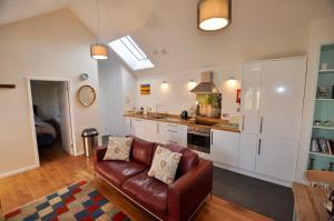 a living room with a couch and a kitchen at Sennen Cove, The Hedgerows, near 14 beaches, in Penzance