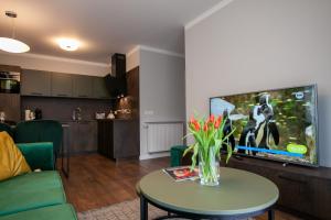 een woonkamer met een tafel en een televisie bij Apartament Leśny No 5 Green ,garaż w cenie in Kielce