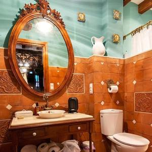 ein Badezimmer mit einem Waschbecken, einem Spiegel und einem WC in der Unterkunft ALOJAMIENTO MAZARI in Antequera