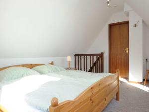 ein Schlafzimmer mit einem Holzbett und einer Holztür in der Unterkunft La Casa Ferienwohnung Uferschwalbe in Steinberg