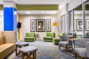 Holiday Inn Express & Suites - Union Gap - Yakima Area, an IHG Hotel في Union Gap: غرفة انتظار وكراسي خضراء وطاولات