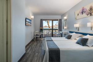 um quarto de hotel com duas camas e uma varanda em Apartamentos Colón Playa em Las Palmas de Gran Canárias