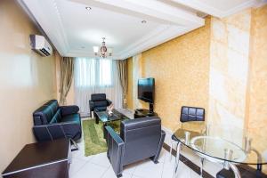 a living room with a table and chairs and a television at Residence Le Carat in Douala