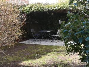 特倫托的住宿－L'angolino apartment，花园内的一张桌子和两把椅子