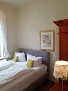 ein Schlafzimmer mit einem Bett mit zwei gelben Kissen in der Unterkunft Waldhotel Forsthaus Remstecken in Koblenz