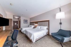 a hotel room with two beds and a chair and a television at Holiday Inn Express & Suites Fort Worth - Fossil Creek by IHG in Fort Worth +23 photos