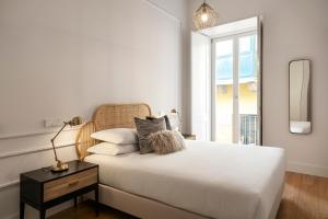 a bedroom with a white bed and a window at Casas da Baixa - Unique Chiado in Lisbon