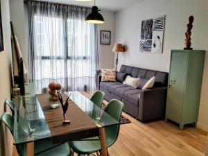 un soggiorno con tavolo e divano di apartamento La Coqueta a Santander