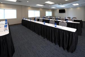 a conference room with tables and chairs and a screen at Holiday Inn Express & Suites - Gaylord, an IHG Hotel in Gaylord