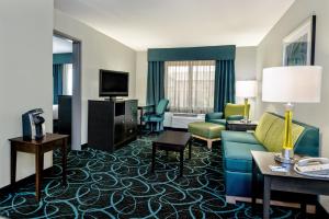 a hotel room with a couch and chairs and a television at Holiday Inn Express Hotel and Suites Fort Worth/I-20 in Fort Worth