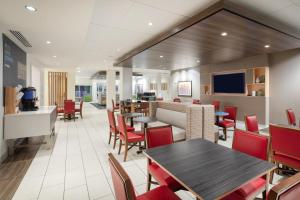 een eetkamer met tafels en rode stoelen bij Holiday Inn Express & Suites Great Bend, an IHG Hotel in Great Bend