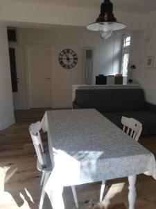 stół i krzesła w salonie z zegarem w obiekcie L'angolino apartment w Trydencie