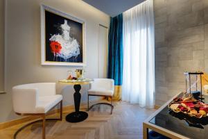 un soggiorno con tavolo, sedie e tavolo con frutta di Dharma Boutique Hotel & SPA a Roma
