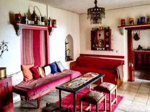 a living room with a red couch and a table at Christianna's Home in Stavrokhórion