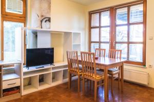 ein Esszimmer mit einem Tisch, Stühlen und einem TV in der Unterkunft Relax apartment in Terme Banovci spa resort in Veržej