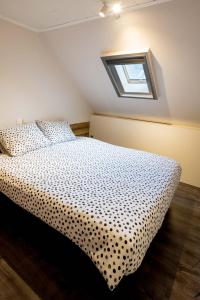 a bedroom with a bed with a black and white comforter at Logies De blauwe regen in Beveren